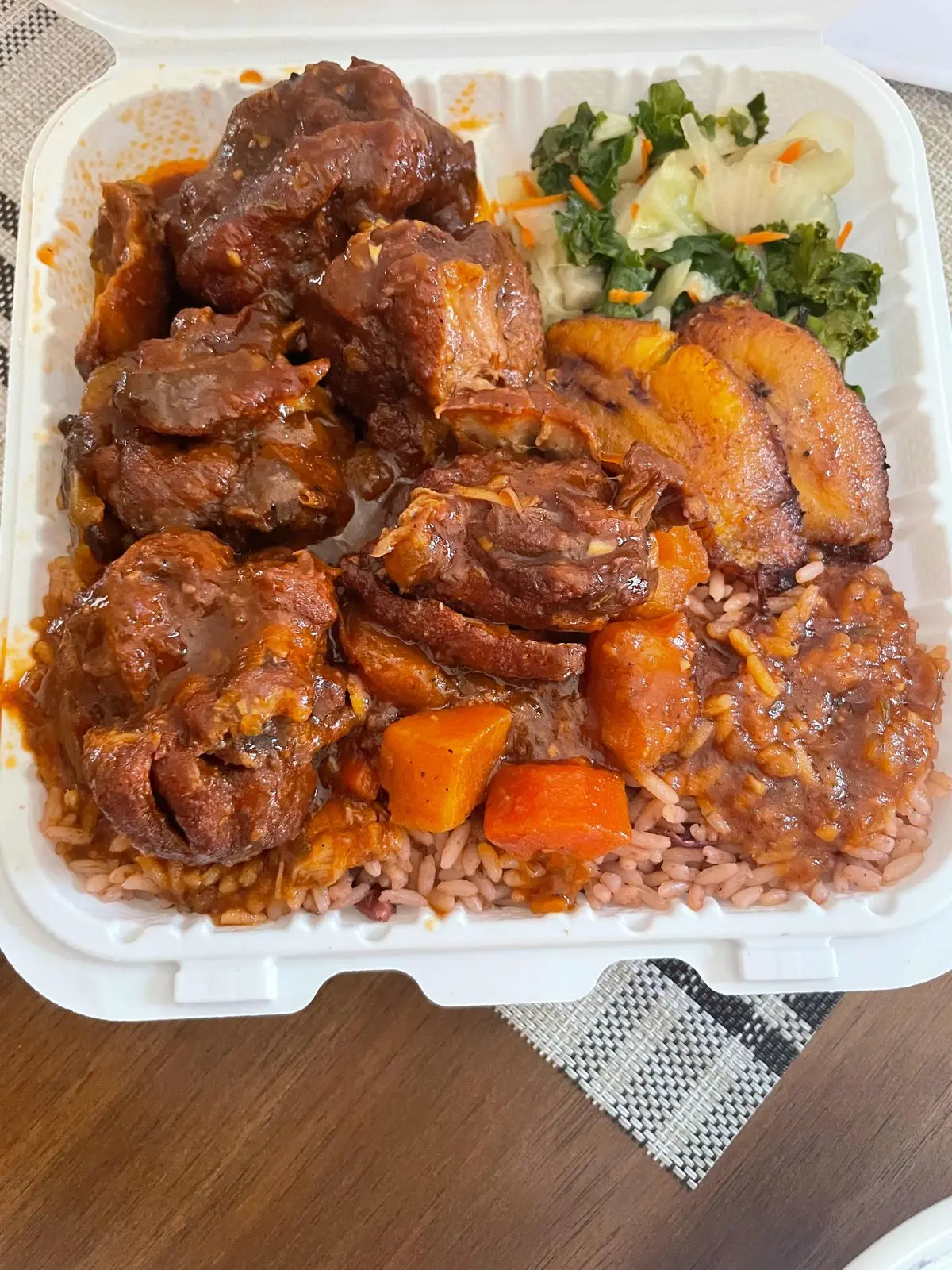 Brown stew chicken served with boiled yam, green banana and dumplings